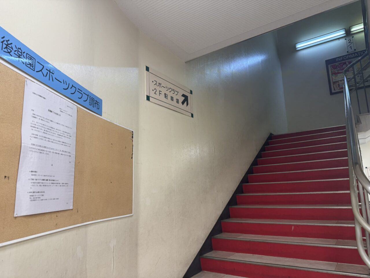 後楽園スポーツクラブ調布の2階へ続く階段と掲示板