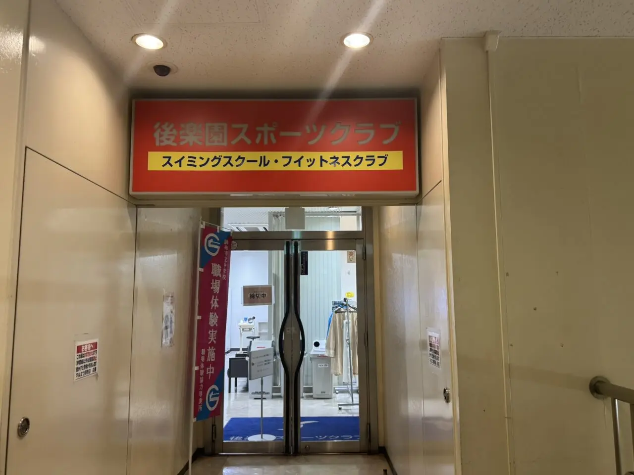 後楽園スポーツクラブ調布の2階入口とフィットネスクラブの看板