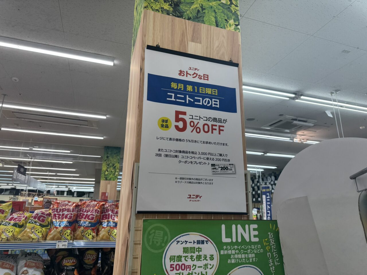 ユニディ狛江店の店内柱に掲示された毎月第1日曜日ユニトコの日などの案内ポスター [source: 4]