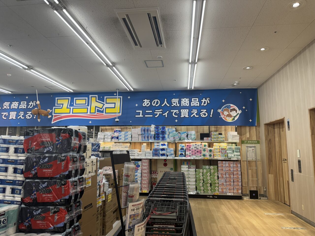 ユニディ狛江店の「あの人気商品がユニディで買える!ユニトコ」の売場看板と商品棚