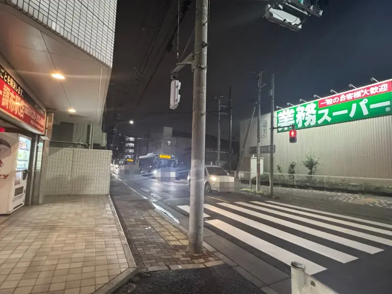 旧甲州街道沿いの道路と通行止め予告看板が置かれた交差点周辺の様子