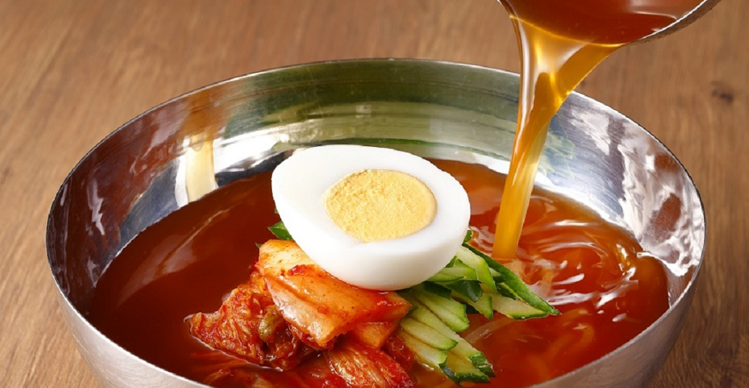 銀色の器に盛り付けられた具だくさんの和民の盛岡冷麺 キャプション：プ